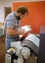 Technician monitoring a computer printout