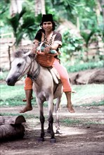 Natives ride a horse in Borneo