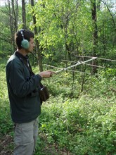 A researcher tracks a radio-tagged yellow-rumped warbler to determine habitat use and length of stay during migration stopover at Trempealeau National Wildlife Refuge ca. 2010