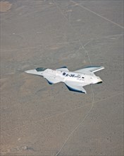 The tailless X-36 technology demonstrator research aircraft cruises over the California desert at low altitude during a 1997 research flight
