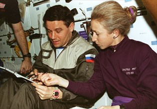 STS-81 Cmdr and MS Ivins with Mir 22 Cmdr review transfer checklists