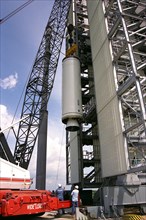 Workers erect the first stage of a Lockheed Martin Launch Vehicle-2 (LMLV-2) at Launch Complex 46 at Cape Canaveral Air Station ca. 1997