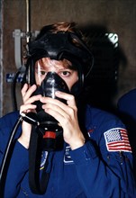 STS-84 Pilot Eileen Marie Collins practices using a gas mask during Terminal Countdown Demonstration Test (TCDT) activities at Launch Pad 39A ca. 1997