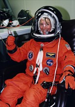 STS-83 Pilot Susan Still gives a thumbs-up as she is assisted into her launch/entry suit in the Operations and checkout (O&C) Building ca. 1997