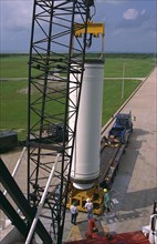 Workers hoist the first stage of a Lockheed Martin Launch Vehicle-2 (LMLV-2) for placement at Launch Complex 46 at Cape Canaveral Air Station (CCAS) ca. 1997