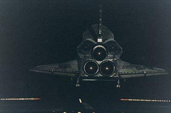 Under the cover of darkness, the Space Shuttle orbiter Discovery glides in for a landing on Runway 15 at KSC's Shuttle Landing Facility ca. 1997
