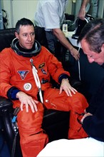 STS-81 Mission Commander Michael A. Baker is assisted into his launch/entry suit in the Operations and Checkout (O&C) Building ca. 1997
