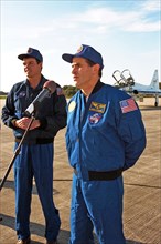 As STS-87 Commander Kevin Kregel looks on, Payload Specialist Leonid Kadenyuk of the National Space Agency of Ukraine addresses members of the press and media ca. 1997