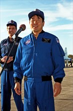 As STS-87 Commander Kevin Kregel looks on, Mission Specialist Takao Doi, Ph.D., of the National Space Development Agency of Japan addresses members of the press and media ca. 1997