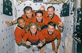 STS-85 crew portraits in the middeck hatch and in front of lockers