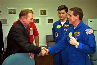 The president of the Ukraine, Leonid Kuchma, shakes hands with Payload Specialist Leonid Kadenyuk, at right, as backup Payload Specialist Yaroslav Pustovyi, both of the National Space Agency of Ukrain...