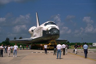 Space Shuttle Orbiter Discovery rolls over from Orbiter Processing Facility 2 on top of the orbiter transporter to the Vehicle Assembly Building for mating with its external tank and solid rocket boos...
