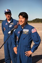 Takao Doi speaking at a microphone after arriving at Kennedy Space Center ca. 1997