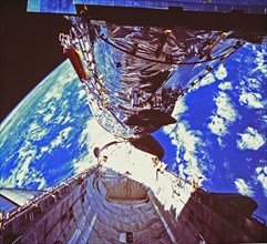 In this photograph, the Hubble Space Telescope (HST) is clearing the cargo bay during its deployment on April 25, 1990. The photograph was taken by the IMAX Cargo Bay Camera (ICBC) mounted in a contai...