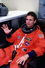 1997 - STS-81 Mission Specialist Jerry Linenger waves to the camera in his launch/entry suit and helmet in the suitup room of the Operations and Checkout (O&C) Building.