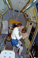 STS-42 Mission Specialist (MS) Hilmers reviews checklist in IML-1 module
