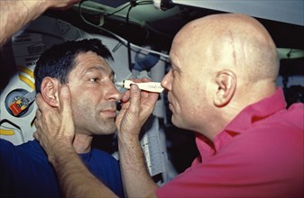 (24 Nov-1 Dec 1991) --- Astronauts F. Story Musgrave (right) and Mario Runco, Jr., mission specialists, team up for one of the biomedical Detailed Supplementary Objective (DSO) tests