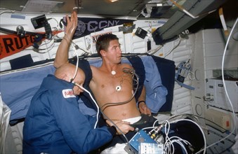 (24 Nov-1 Dec 1991) --- Astronaut F. Story Musgrave (left), Mission Specialist, assists Astronaut Terence T. (Tom) Henricks, Mission Specialist, with a Detailed Supplementary Objective (DSO) involving...