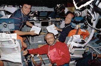 STS-46 "blue" shift crewmembers look up from work on OV-104's flight deck