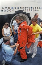 STS-40 MS Jernigan dons LES parachute pack prior to egress training at JSC