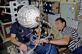 (22-30 Jan. 1992) --- Astronaut David C. Hilmers (right), STS-42 mission specialist, assists European Space Agency (ESA) payload specialist Ulf Merbold with the visual stimulator experiment on the Spa...