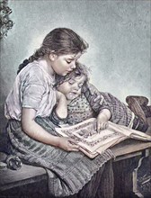 Zwei Mädchen sind in einem Bilderbuch vertieft