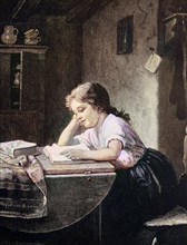 Schulmädchen liest zuhause aufmerksam in einem Buch
