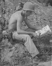 American soldier resting with magazine and beer, Korean War