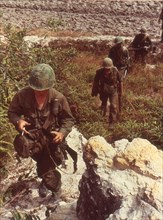 American patrol searches for Viet Cong in a rocky area near Saigon. Vietnam, 1967.