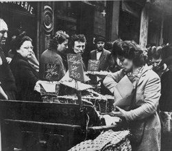 Somber French shoppers see the result of rampant inflation in the rising prices of consumer goods, France, circa 1947.