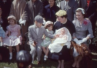 First Lady Mamie Eisenhower, holding her youngest grandchild and sitting with her daughter-in-law Barbara (right) and three other grandchildren. Washington, DC, 1955.