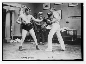Boxer Tommy Burns (left) sparring with a partner. Circa 1908.