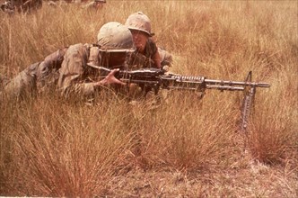 Men of the 1st Inf Div draw sniper fire while on a search and destroy mission. Bien Hoa, Vietnam, 10/65.