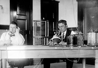 Two men sitting in what the original caption calls a laboratory
