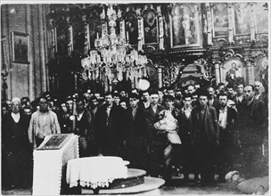 Serbian civilians who are being forced to convert to Catholicism by the Ustasa regime stand in