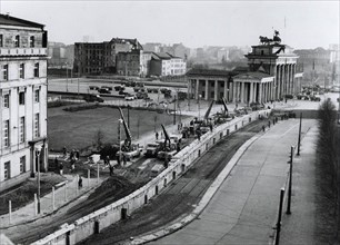 Berlin wall reinforced. Under the watchful eye of Communist police, East german workers near the