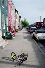 June 11, 1998 - small bike lying on sidewalk in urban neighborhood