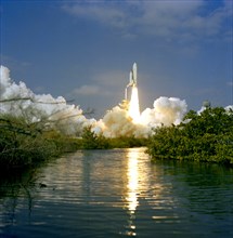 (12 Nov. 1981) --- Framed here by Florida vegetation, the 37-meter-tall (122 feet) NASA space shuttle Columbia lifts off from Launch Pad 39A at NASA-Kennedy Space Center (KSC). Astronauts Joe H. Engle...