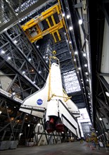 A large yellow, metal sling lifts shuttle Endeavour