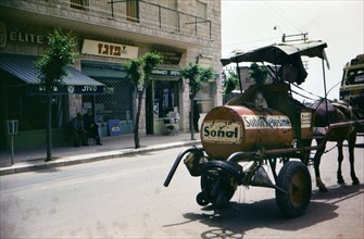 A horse drawn cart pulls a tank of kerosene