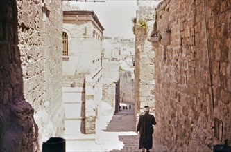 Old man walking down street within the city walls of Jerusalem