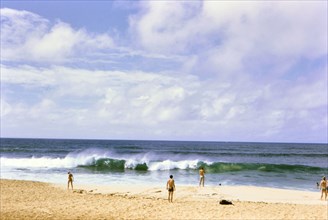 Tourists / beachgoers enjoying the surf and beach in Oahu Hawaii ca. 1973