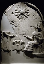 Upper section of a stele with depiction of a libation scene before a seated god