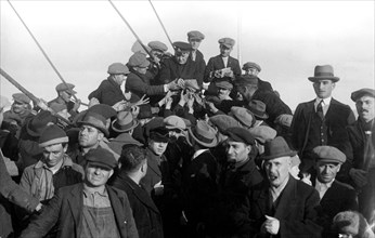 sur le pont avant du conte verde un groupe d'émigrants autour de l'aumônier. 1915-40