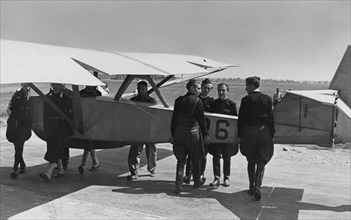 le transport d'un avion sur l'aérodrome pour l'école de vol et de vol à voile. le type date de 1939.