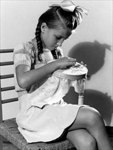 little girl embroidering, 1949