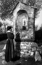 italy, woman praying at chapel, 1910