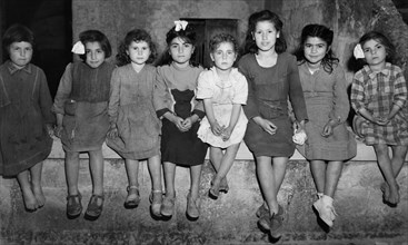 un groupe d'enfants pose pour un peintre, 1952
