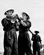 équipe agip en activité de recherche avec une plate-forme de forage, 1954