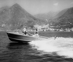 touristes au bord du lac sur le bateau à moteur triton du chantier naval riva à sarnico, 1961